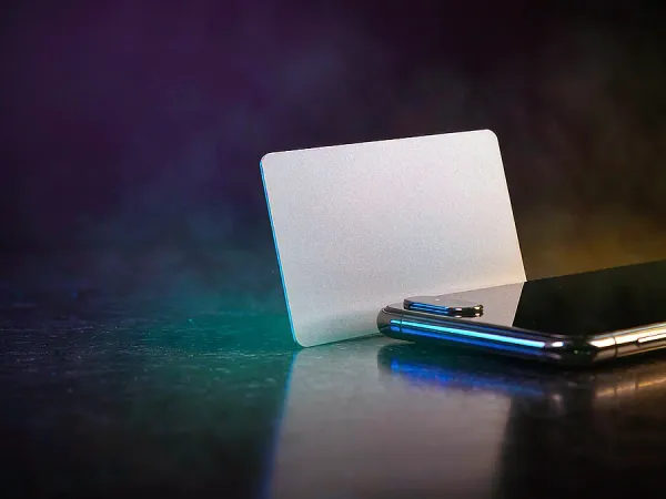 eg777 + Blank card standing beside a smartphone